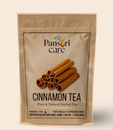 Pansari Care Cinnamon Tea in a clear glass teacup, with cinnamon sticks and powder.